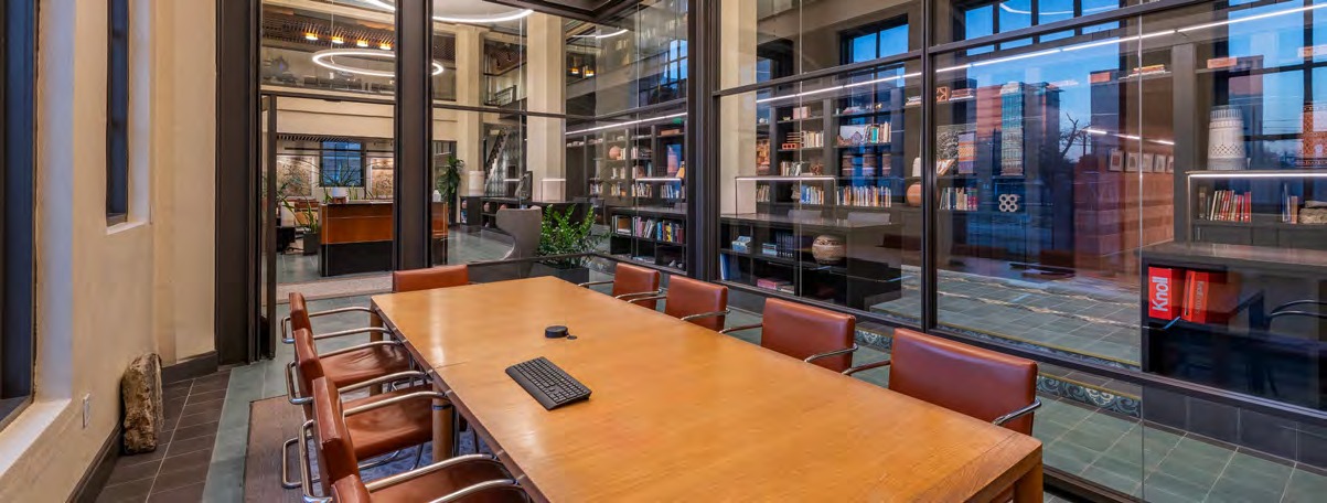 A Light Building meeting space with a long conference table, chairs, and daylight from large windows.